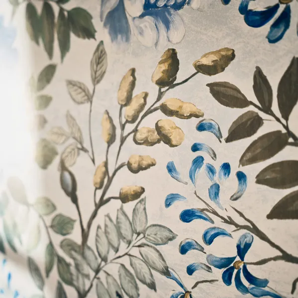 Vintage-Blumentapete mit gemalten blauen Blumen und grünen Blättern