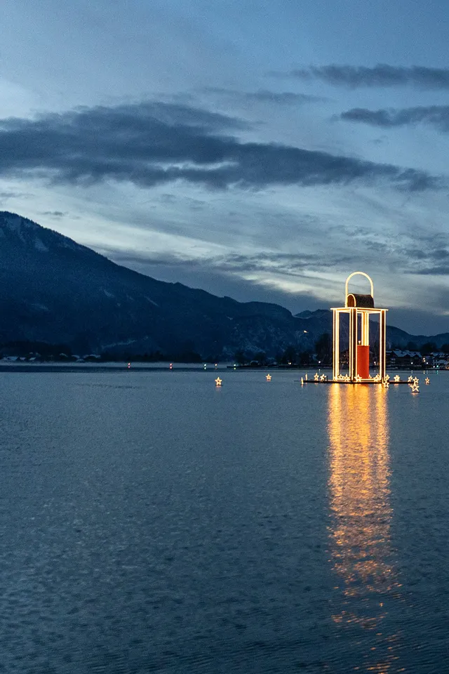 St. Wolfgang village and illuminated Christmas lantern on Lake Wolfgang at twilight