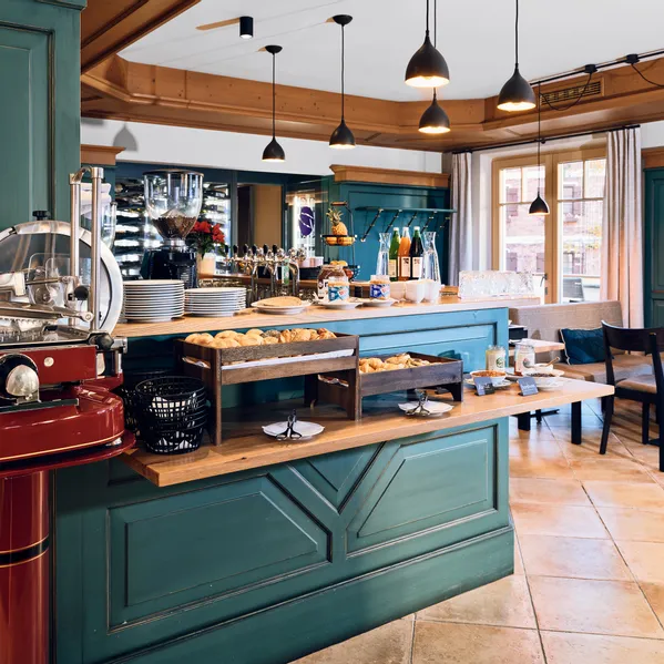 Gemütliches Café-Frühstücksbuffet mit Gebäck, Kaffeemaschine und rustikaler Holzeinrichtung