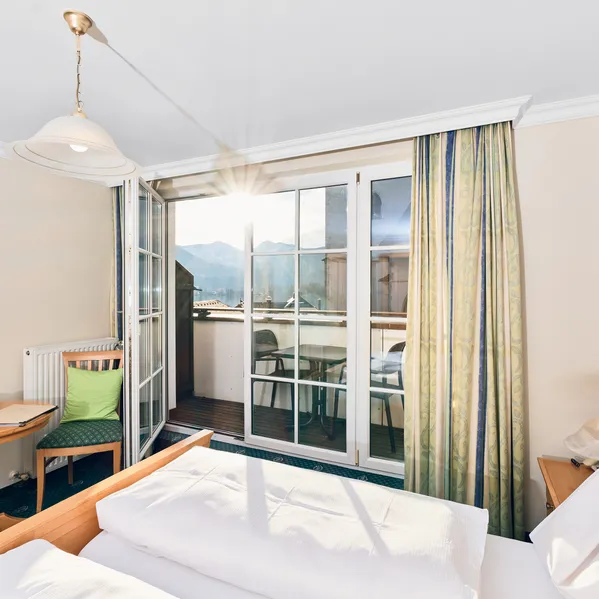 Gemütliches Hotelzimmer mit Balkon und Bergblick bei Sonnenaufgang