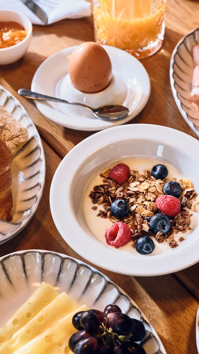 Traditionelles europäisches Frühstück mit Croissants, Aufschnitt, Joghurt mit Beeren, Obst und Käse