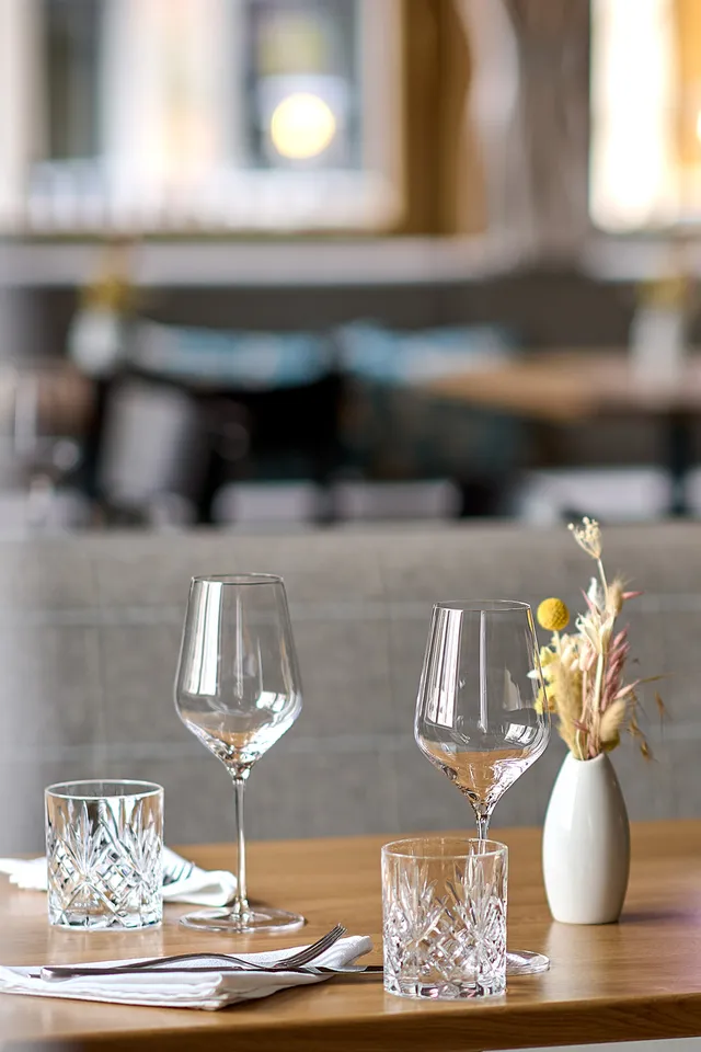 Eleganter Restauranttisch mit Weingläsern, Wassergläsern und Trockenblumen als Tischdeko