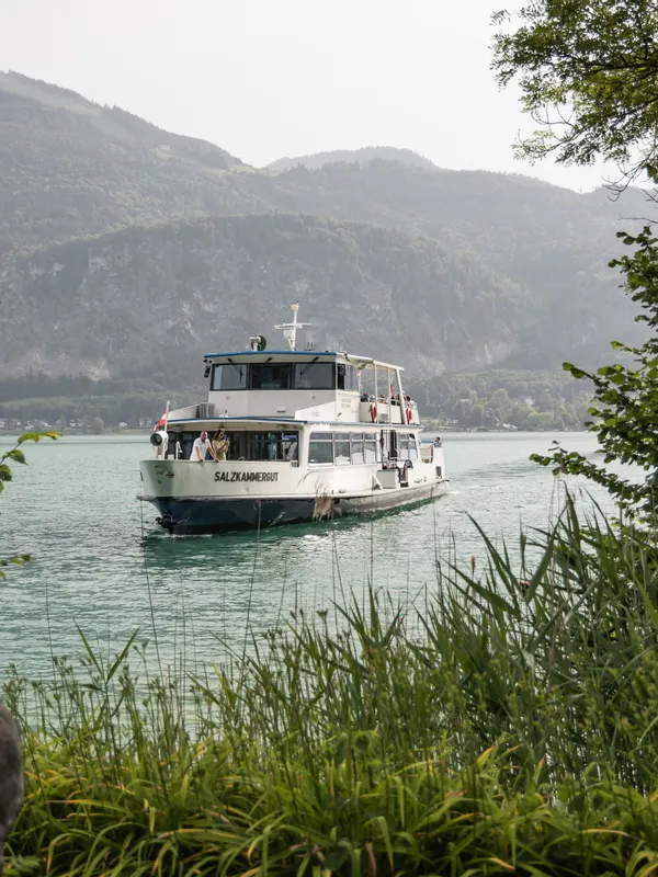 Tourist boat Salzkammergut cruising on a scenic lake surrounded by mountains and greenery