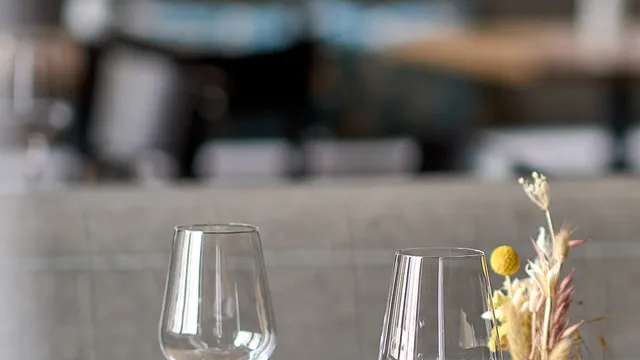 Eleganter Restauranttisch mit Weingläsern, Wassergläsern und Trockenblumen als Tischdeko
