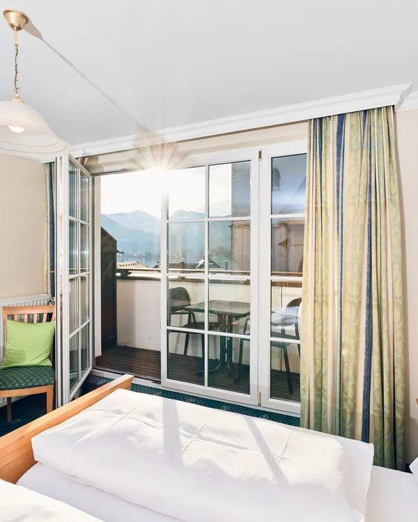 Gemütliches Hotelzimmer mit Balkon und Bergblick bei Sonnenaufgang