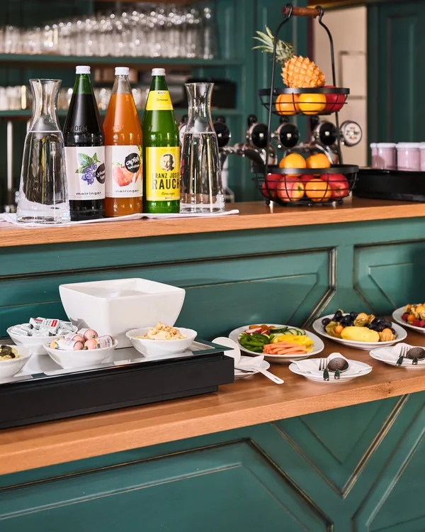 Frühstücksbuffet mit Obst, Aufstrichen, Saftflaschen und Joghurt in modernem Hotelambiente