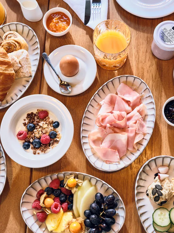 Kontinentales Frühstück mit Aufschnitt, Käse, Obst, Gebäck, Eiern, Saft und Müsli