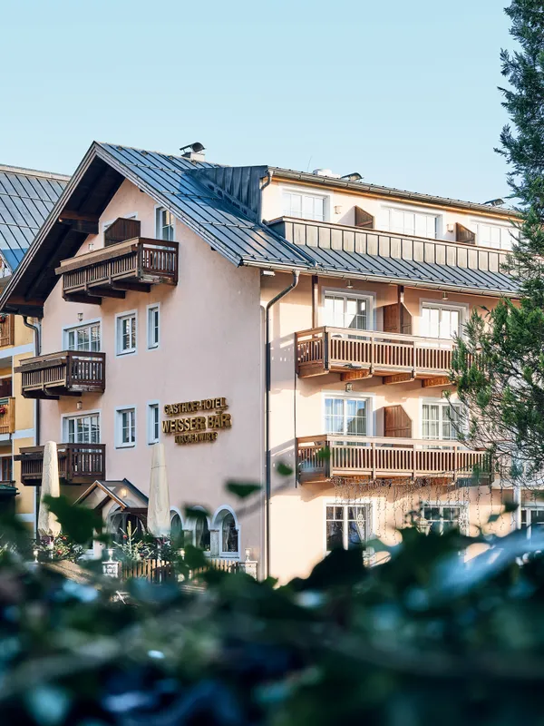 Traditionelles Alpen-Gasthotel mit Balkonen und Holzdach in einem Bergdorf